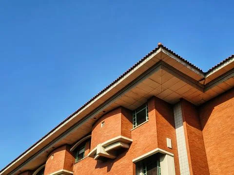 A stunning low-angle shot of a red brick building against a bright blue sky Stock Photos