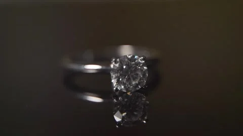 A stunning macro shot of a solitaire diamond engagement ring on a dark Stock Footage 321189538