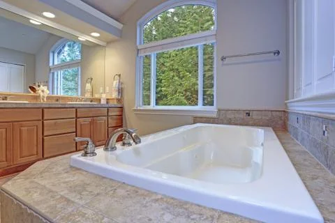 Stunning master bathroom with double vanity cabinet, large arched window, vau Stock Photos