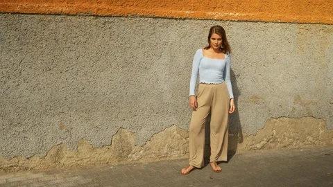 Stunning Model Standing with Concrete Wall in Background Posing Video stock 115842527