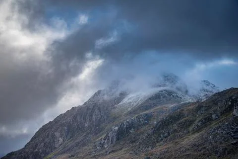 Stunning moody dramatic Winter landscape image of snowcapped Tryfan mountain  Stock Photos