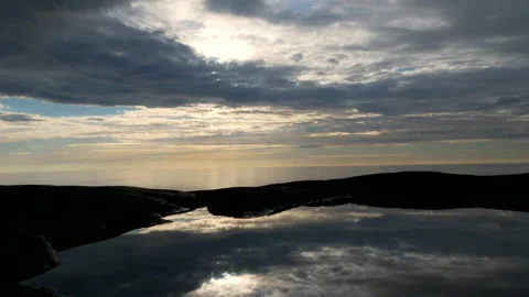 Stunning motion time lapse of moving cloudscape over cliffs reflected in Stock Footage 135844867