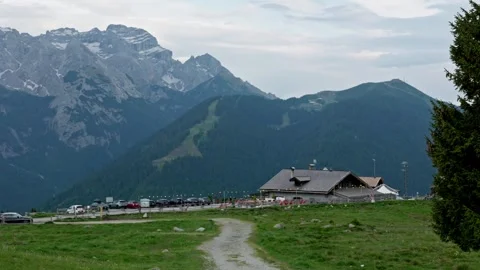 Stunning mountain landscape featuring a traditional refuge and a parking lot. A Stock-Footage 337137626