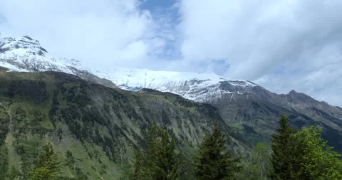 Stunning mountain range with snow-capped peaks and lush green valleys in Video stock 314082118