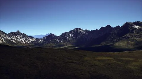 Stunning mountain range under clear blue sky during daylight hours Stock Illustration