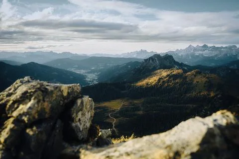 A stunning mountain range view with trees and rocks in the foreground Stock Photos