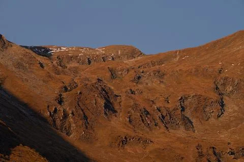 Stunning mountain red rock ascent in sun light with sow cover Stock Photos