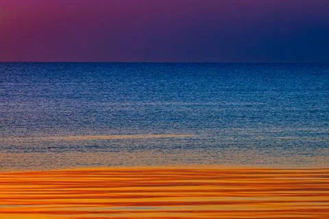 A stunning ocean view at sunset with deep blue waters and a sky Stock Photos