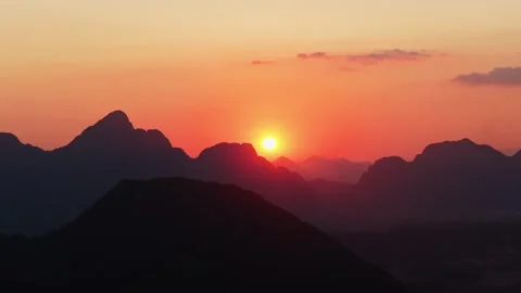 Stunning orange sky at sunset above limestone peaks of Laos from tripod aerial p 库存影片 335311376