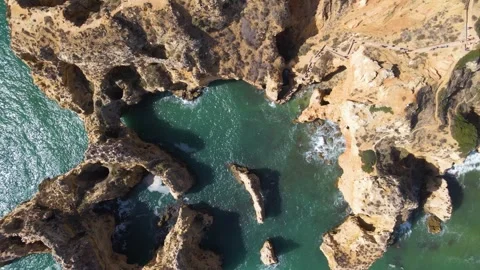 Stunning overhead drone view of heart shaped sea cave grotto in Algarve showing Stock Footage 330923933
