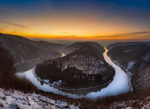 A stunning panoramic view of a river winding through a snow-dusted valley a.. Stock Photos