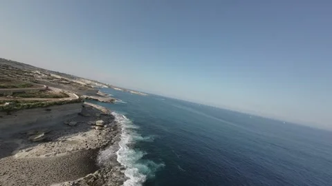 Stunning RAW cinematic dynamic zoom-in shot over the seashore with FPV drone Stock Footage 248690755