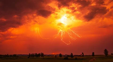 A stunning red sky lightning storm. Climate change concept Stock Photos