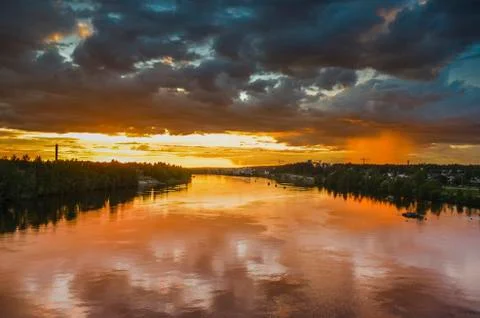 Stunning reflection of sunlight on moving cloud and local rain on the river t Stock Photos