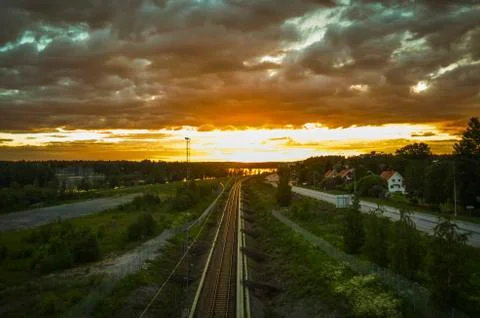 Stunning reflection of sunlight on moving cloud and leading train line to the Stock Photos