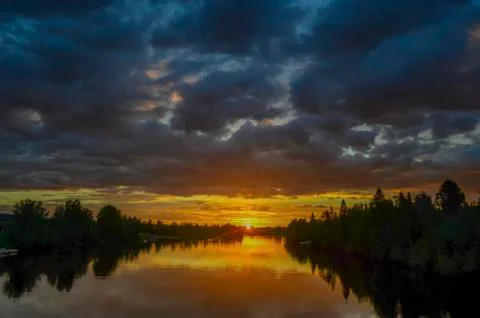 Stunning reflection of sunlight on moving cloud and reflection on the river t Stock Photos