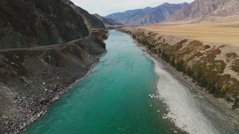 Stunning river flows through mountains in remote wilderness during autumn Видео 307133067
