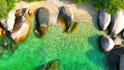 Stunning sandy beach with rock, clean sea water and green forest. 4K. Stock Footage 265986084