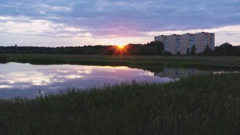 Stunning Scenic Sunset Reflection Over Calm Water Featuring Buildings in the Stock Footage 280791424