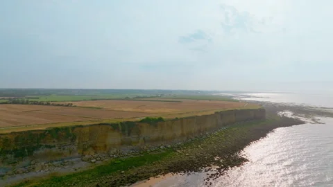 Stunning Seaside Cliffs with Fields on Top and Open Sea Stock Footage 316239592
