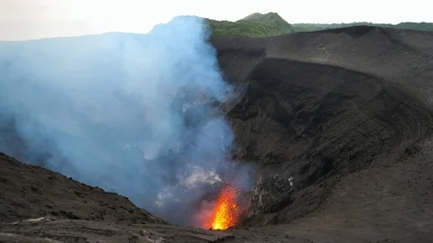 Stunning shot of an active volcano spewing out glowing lava high in the air. Stock Footage 103121235