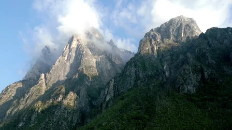 Stunning shot capturing mountains with clouds hovering above in the 動画素材 261145792