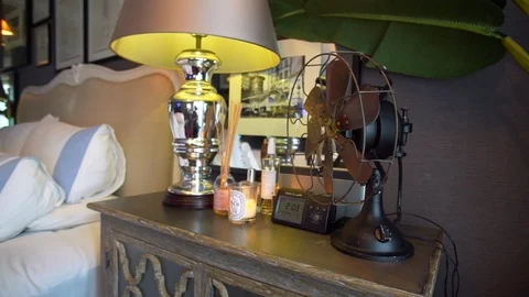 Stunning shot of a rustic nightstand with a modern fan and lamp on the Stock Footage 116189086