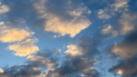 Stunning sky scene with fluffy clouds at sunset displaying a beautiful pale.. Stock Photos