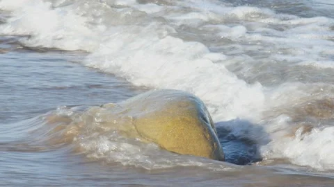 Stunning slow-motion close-up captures the persistence of nature as foamy oc Vídeos de archivo 318689903
