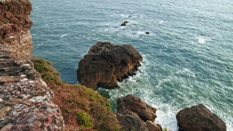 Stunning slow-motion ocean waves crashing into the edge of the rocky seashore. Stock Footage 169201645