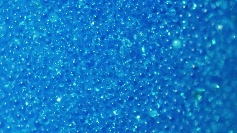 Stunning soft blue background made of tiny quartz beads. Sand pours slowly into  Stock Footage 252805271