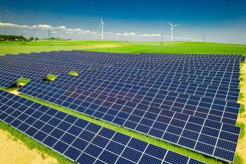 Stunning solar panels, green field and blue sky, aerial view Stock Photos