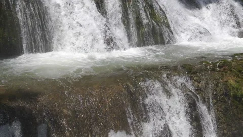 Stunning splash of a cascading waterfall against a picturesque landscape Stock Footage 312526019