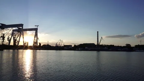 Stunning steady view on warm orange evening sunset sky over crane manufacturing Stock Footage 92866658