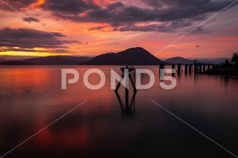 A stunning sunset across the flat calm waters just off the coast of Wrangell, Stock Photos