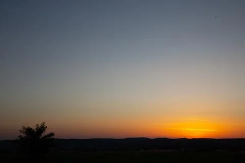 A stunning sunset illuminates the sky, casting a warm glow over the landscape Stock Photos
