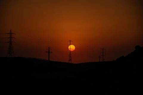 Stunning sunset illuminating a vast array of power towers and electrical wires Stock Photos