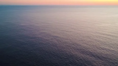 Stunning Sunset Over Calm Ocean Waters Captured From Above at a Coastal Location Stock Footage 334930478
