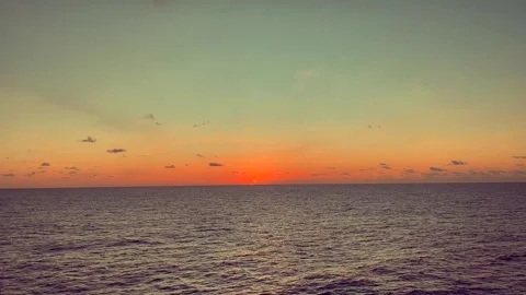 A stunning sunset over the calm ocean horizon with vibrant colors in the sk.. Stock Footage 338280460