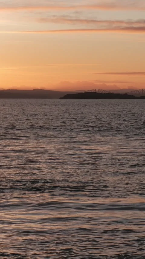 Stunning sunset over Firth of Forth with lighthouse view, vertical Stock Footage 302519067
