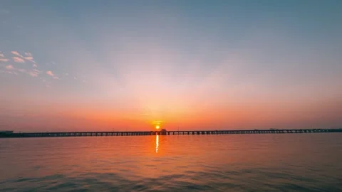 Stunning sunset over a long bridge crossing a calm body of water Stock Footage 342209434