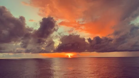 Stunning sunset over the ocean with vibrant orange and pink clouds reflecti.. Stock Footage 338282222
