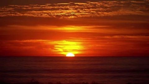 A stunning sunset over the Pacific Ocean with a fiery sky in 4K Stock Footage 283460611