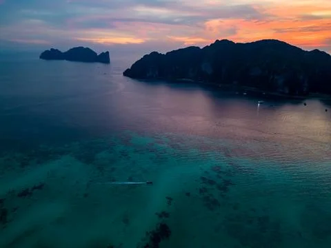 A stunning sunset over a small Phi Phi islands surrounded by sea and clouds Stock Photos