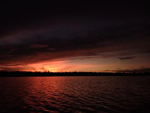 Stunning Sunset Reflection Over Rippling Dark Water Surface at Twilight Foto stock