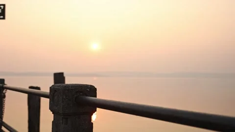 Stunning Sunset Reflections on Dock Railing Stock Footage 238511034