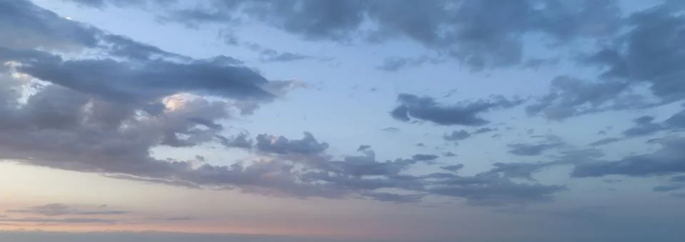 A stunning sunset sky with clouds in various shades of blue and pink. A perfect Stock Photos