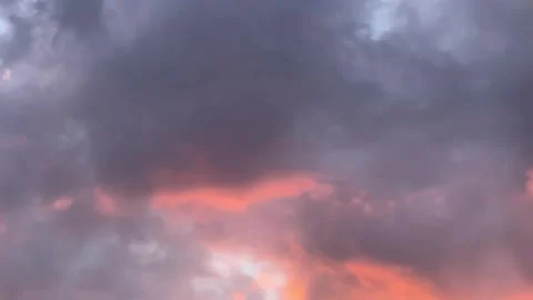 A stunning sunset sky filled with dramatic, glowing orange and dark moody clouds Vídeo Stock 333595225