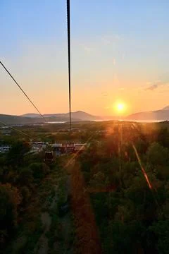Stunning sunset view from a cable car over green landscape Stock Photos