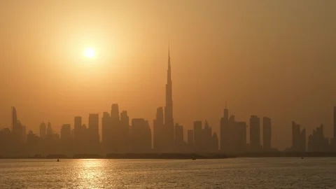Stunning sunset view of the hazy Dubai skyline with the iconic Burj Khalifa.. Video stock 347901341